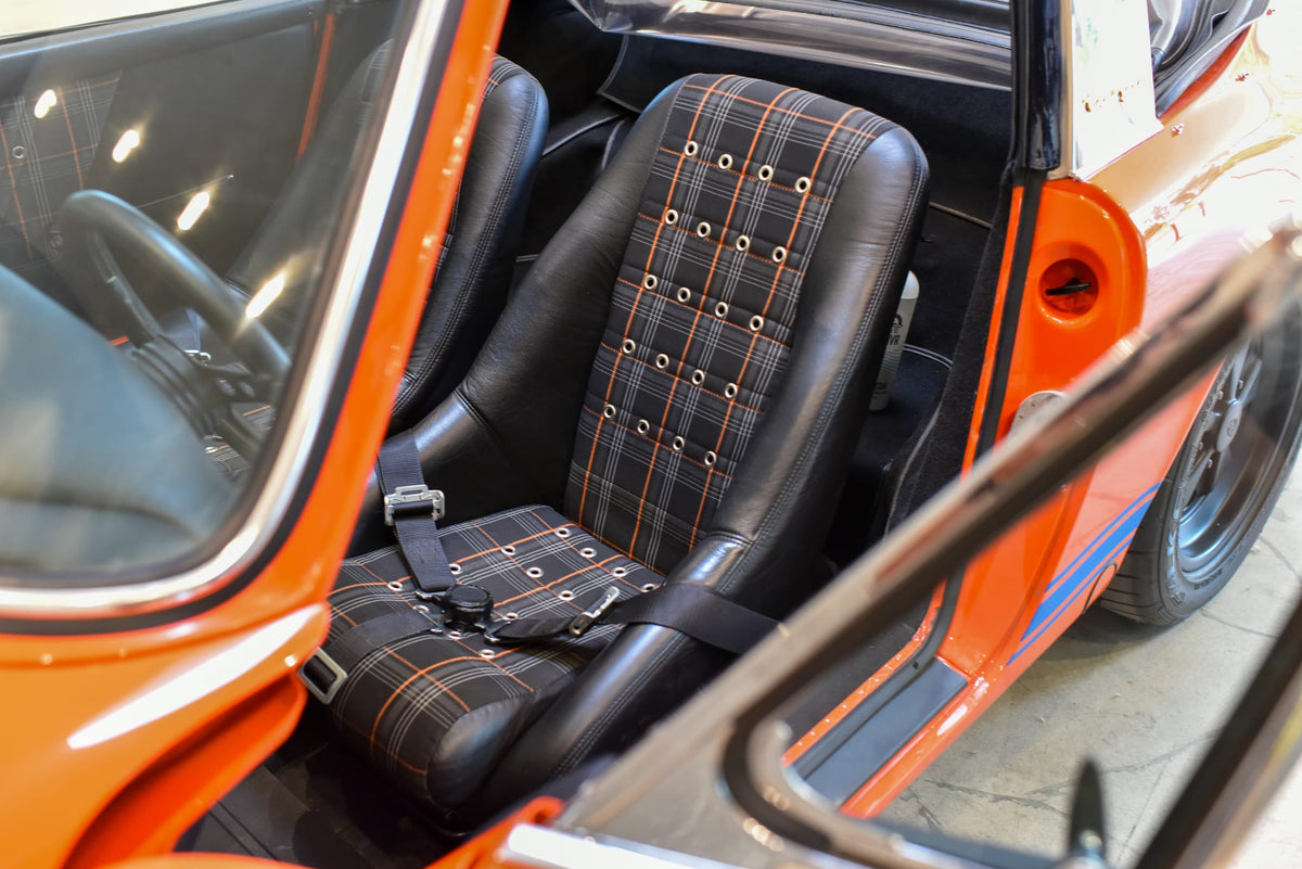 Black leather and plaid fixed-back bucket seats